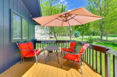 a porch with a table and chairs and an umbrella at Walk to Lake Carobeth Gem in Pocono Country Place in Tobyhanna