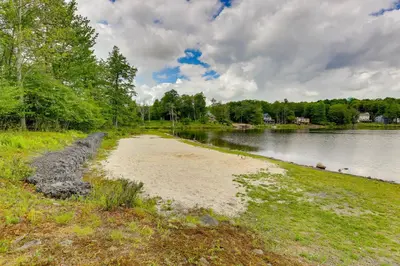 a sandy beach next to a body of water at Walk to Lake Carobeth Gem in Pocono Country Place in Tobyhanna