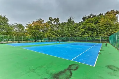 a tennis court with a blue tennis court at Walk to Lake Carobeth Gem in Pocono Country Place in Tobyhanna
