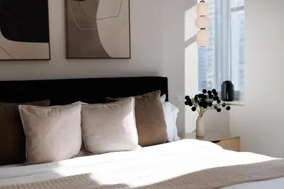 a bedroom with a bed with white sheets and pillows at RARE Luxurious Apartment 1 Block From Time Square in New York