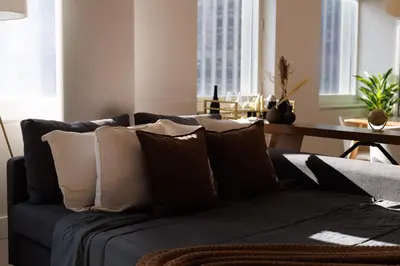 a living room with a blue couch with pillows at RARE Luxurious Apartment 1 Block From Time Square in New York