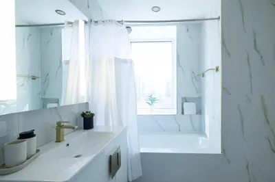 a white bathroom with a sink and a shower at RARE Luxurious Apartment 1 Block From Time Square in New York