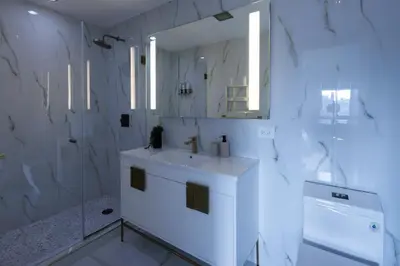 a white bathroom with a sink and a mirror at RARE Luxurious Apartment 1 Block From Time Square in New York