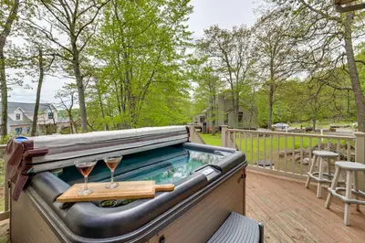 a hot tub on a deck with two glasses of wine at Less Than 1 Mi to Big Boulder Mtn! Home with Hot Tub and Deck in Lake Harmony