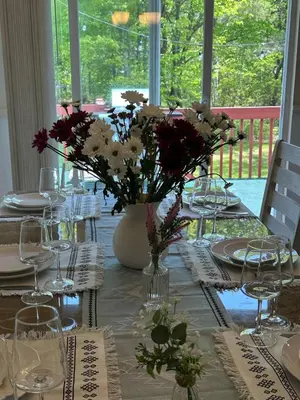 a table with a vase of flowers on it at Joy Cabin Where Family Friends Make Memories in Long Pond