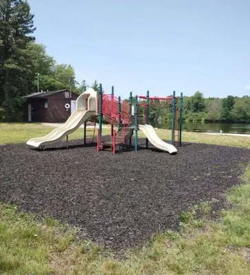 a playground with a slide in a park at Joy Cabin Where Family Friends Make Memories in Long Pond