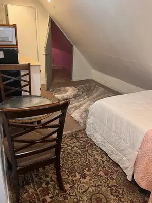 a bedroom with a bed and a desk and a chair at Atic Apartment in Perth Amboy