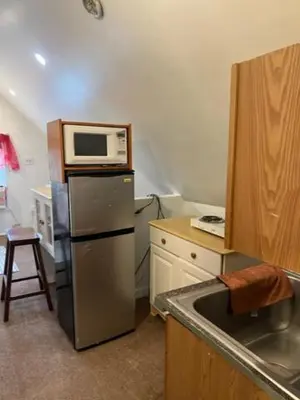 a kitchen with a microwave on top of a refrigerator at Atic Apartment in Perth Amboy