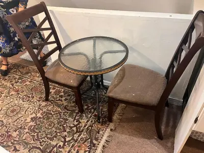 a glass table and two chairs and a table and a chair at Atic Apartment in Perth Amboy