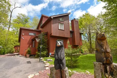 a house with a bear statue in front of it at Bool Bear Lodge a pet friendly Pocono Vacation Home with Fireplace, BBQ and more in Tobyhanna