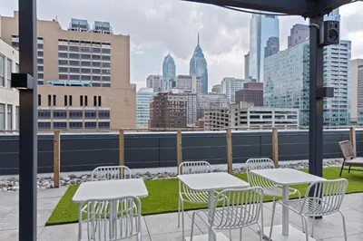 a patio with tables and chairs and a view of the city at Sosuite at The Onyx - Museum District in Philadelphia