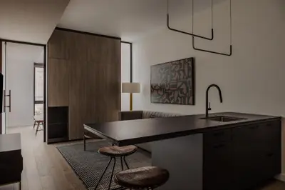 a kitchen with a sink and a counter with stools at Sosuite at The Onyx - Museum District in Philadelphia