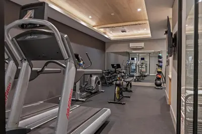 a gym with treadmills and bikes in a room at Sosuite at The Onyx - Museum District in Philadelphia