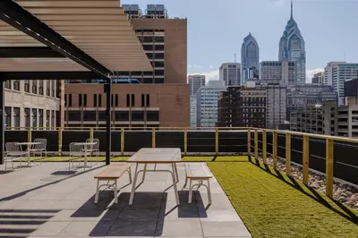 a patio with a table and chairs and a city skyline at Sosuite at The Onyx - Museum District in Philadelphia