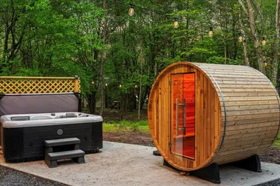 a wooden tub sitting next to a bench next to a tree at 5 Br Sleeps 14 Hot Tub-Sauna-Movie Theatre-Arcade in Albrightsville