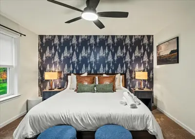a bedroom with a large bed with a ceiling fan at 5 Br Sleeps 14 Hot Tub-Sauna-Movie Theatre-Arcade in Albrightsville
