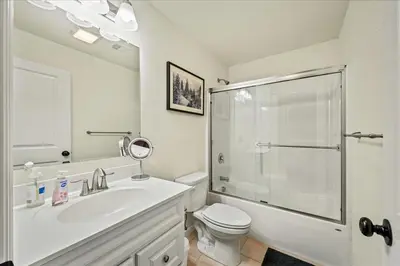 a white bathroom with a shower and a toilet at 5 Br Sleeps 14 Hot Tub-Sauna-Movie Theatre-Arcade in Albrightsville