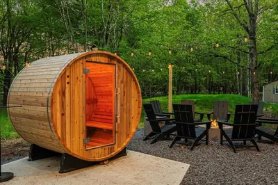 a wooden circular building with chairs and a table at 5 Br Sleeps 14 Hot Tub-Sauna-Movie Theatre-Arcade in Albrightsville