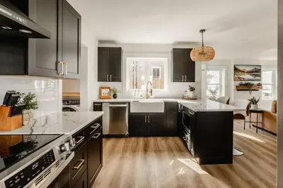 a kitchen with black cabinets and a kitchen island at Modern Amish Country Retreat w/ Hot Tub. in Leola