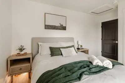 a bedroom with a bed with a green blanket on it at Modern Amish Country Retreat w/ Hot Tub. in Leola