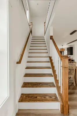 a staircase in a house with white walls and wooden floors at Modern Amish Country Retreat w/ Hot Tub. in Leola