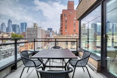 a table and chairs on a balcony with a view of the city at Blueground Chelsea rooftop nr The High Line NYC-1201 in New York
