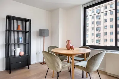a dining room with a table and chairs and a window at Blueground Chelsea rooftop nr The High Line NYC-1201 in New York