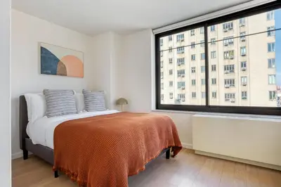 a bedroom with a bed and a large window at Blueground Chelsea rooftop nr The High Line NYC-1201 in New York