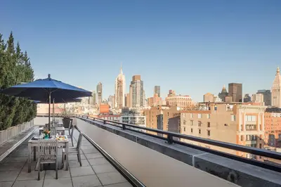 a table with an umbrella on top of a building at Blueground Chelsea rooftop nr The High Line NYC-1201 in New York