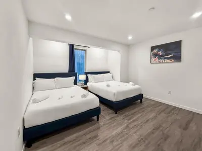a bedroom with two beds and a painting on the wall at Apartmint at Fishtown Flats - Philadelphia in Philadelphia