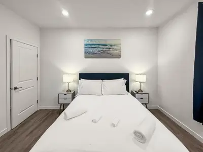 a white bedroom with a large bed with two lamps at Apartmint at Fishtown Flats - Philadelphia in Philadelphia