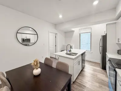 a kitchen and dining room with a table and a sink at Apartmint at Fishtown Flats - Philadelphia in Philadelphia