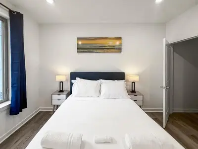 a bedroom with a large white bed with two lamps at Apartmint at Fishtown Flats - Philadelphia in Philadelphia