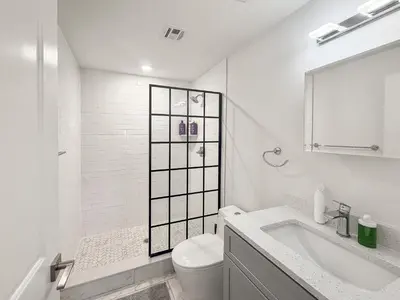 a white bathroom with a toilet and a sink at Apartmint at Fishtown Flats - Philadelphia in Philadelphia