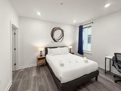 a bedroom with a large white bed and a mirror at Apartmint at Fishtown Flats - Philadelphia in Philadelphia