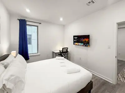 a white bedroom with a large bed and a window at Apartmint at Fishtown Flats - Philadelphia in Philadelphia