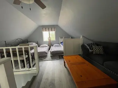 a attic room with two beds and a couch at Masthope Retreat in Lackawaxen