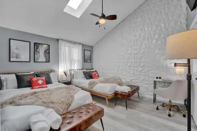a bedroom with two beds and a couch at Pocono Blue with Paddleboards, Spa, Indoor Jacuzzi, GameRoom, Lake, EV in Gouldsboro