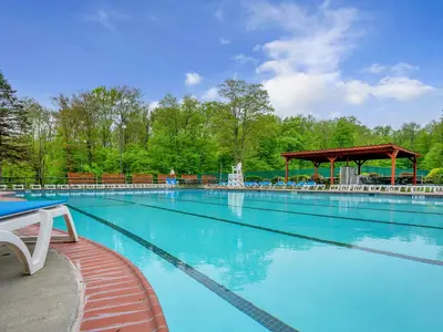 a large blue swimming pool with a gazebo at Pocono Blue with Paddleboards, Spa, Indoor Jacuzzi, GameRoom, Lake, EV in Gouldsboro