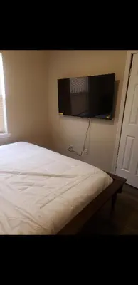 a bedroom with a bed and a flat screen tv on the wall at Beautiful 3 Bed Vacation home in Newark