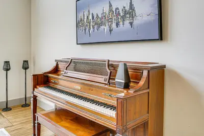 a piano in a room with a painting on the wall at Walk to Bethel Woods Family Home with Deck and Views! in Swan Lake
