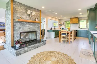 a kitchen and living room with a fireplace at Walk to Bethel Woods Family Home with Deck and Views! in Swan Lake
