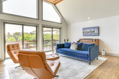 a living room with a blue couch and two chairs at Walk to Bethel Woods Family Home with Deck and Views! in Swan Lake