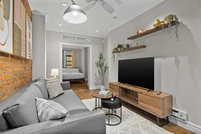 a living room with a couch and a flat screen tv at Stylish Escape in the East Village in New York