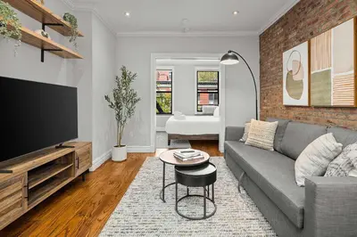 a living room with a couch and a flat screen tv at Chic NYC Escape in Vibrant Downtown in New York