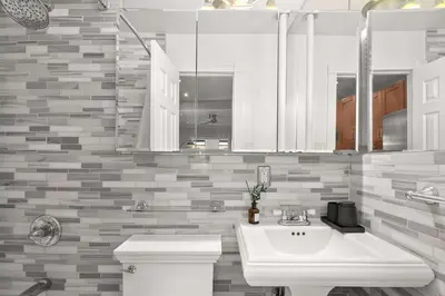 a bathroom with a white sink and a toilet at Chic NYC Escape in Vibrant Downtown in New York