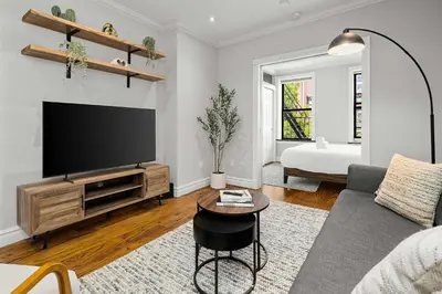 a living room with a tv and a couch at Chic NYC Escape in Vibrant Downtown in New York