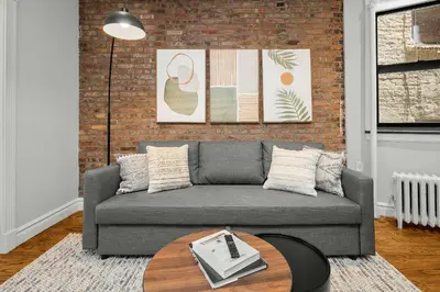 a living room with a couch and a table at Chic NYC Escape in Vibrant Downtown in New York