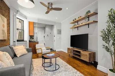 a living room with a couch and a flat screen tv at Chic NYC Escape in Vibrant Downtown in New York
