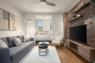 a living room with a couch and a brick wall at Stylish East Side Escape Steps from Fun in New York